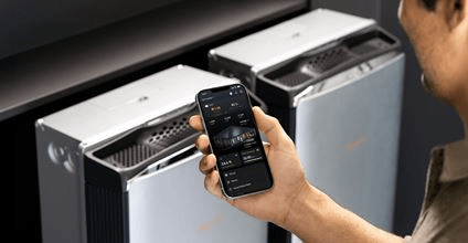 A homeowner and a dealer looking over a phone together next to a Generac home standby generator